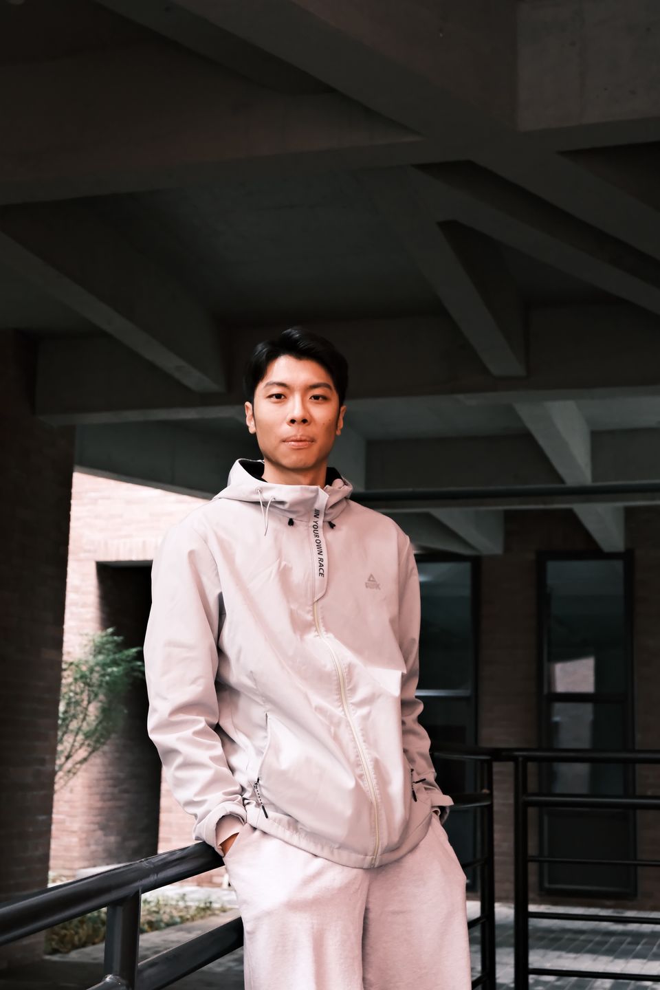Siyuan Xue outdoors in light athletic wear against concrete architecture