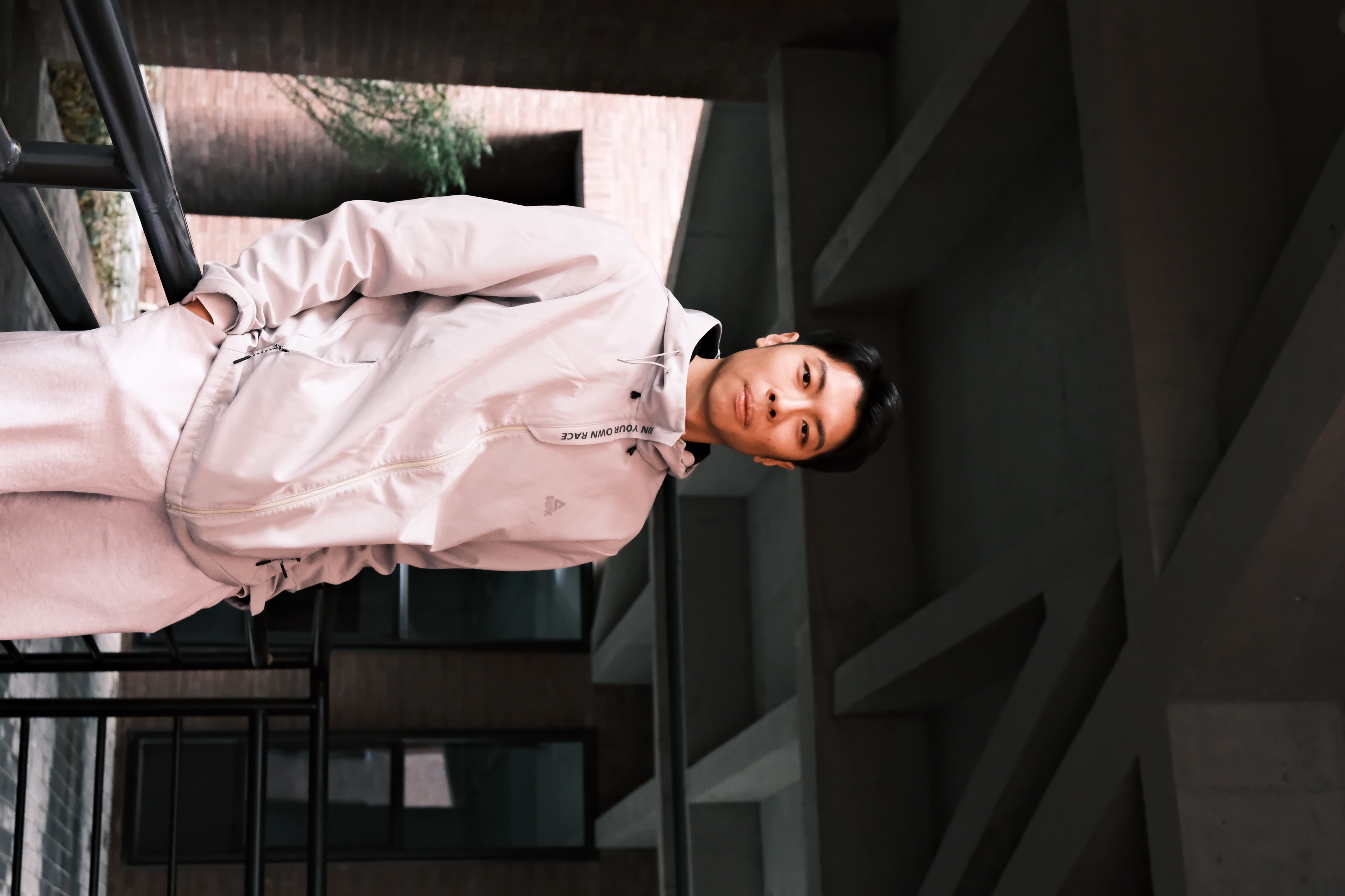 Siyuan Xue outdoors in light athletic wear against concrete architecture