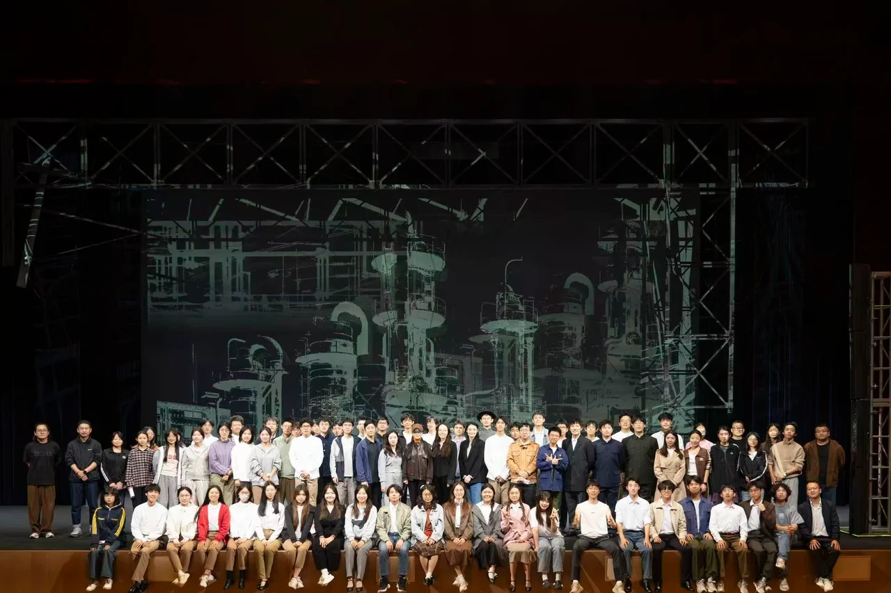 A large group photograph of the Walking with Light company on stage, in front of a scientific-instrument set