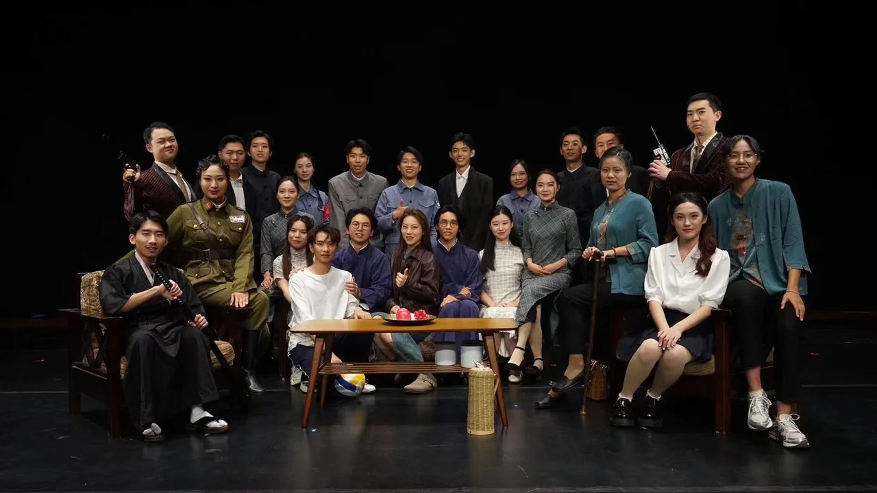 The Finding Li Bai company posing on stage, standing or seated around the sofa and coffee table