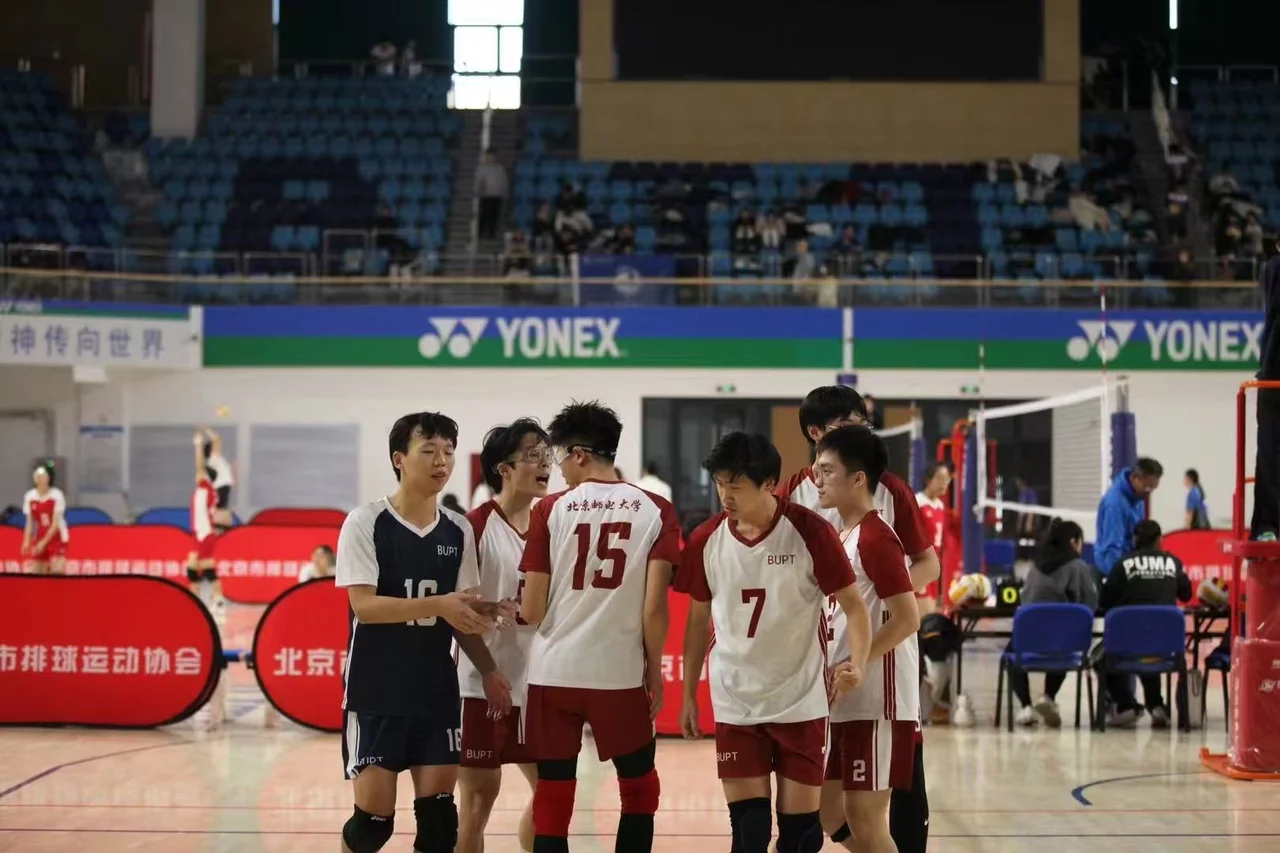 University team players in red-and-white BUPT jerseys and dark jerseys gathered beside the net