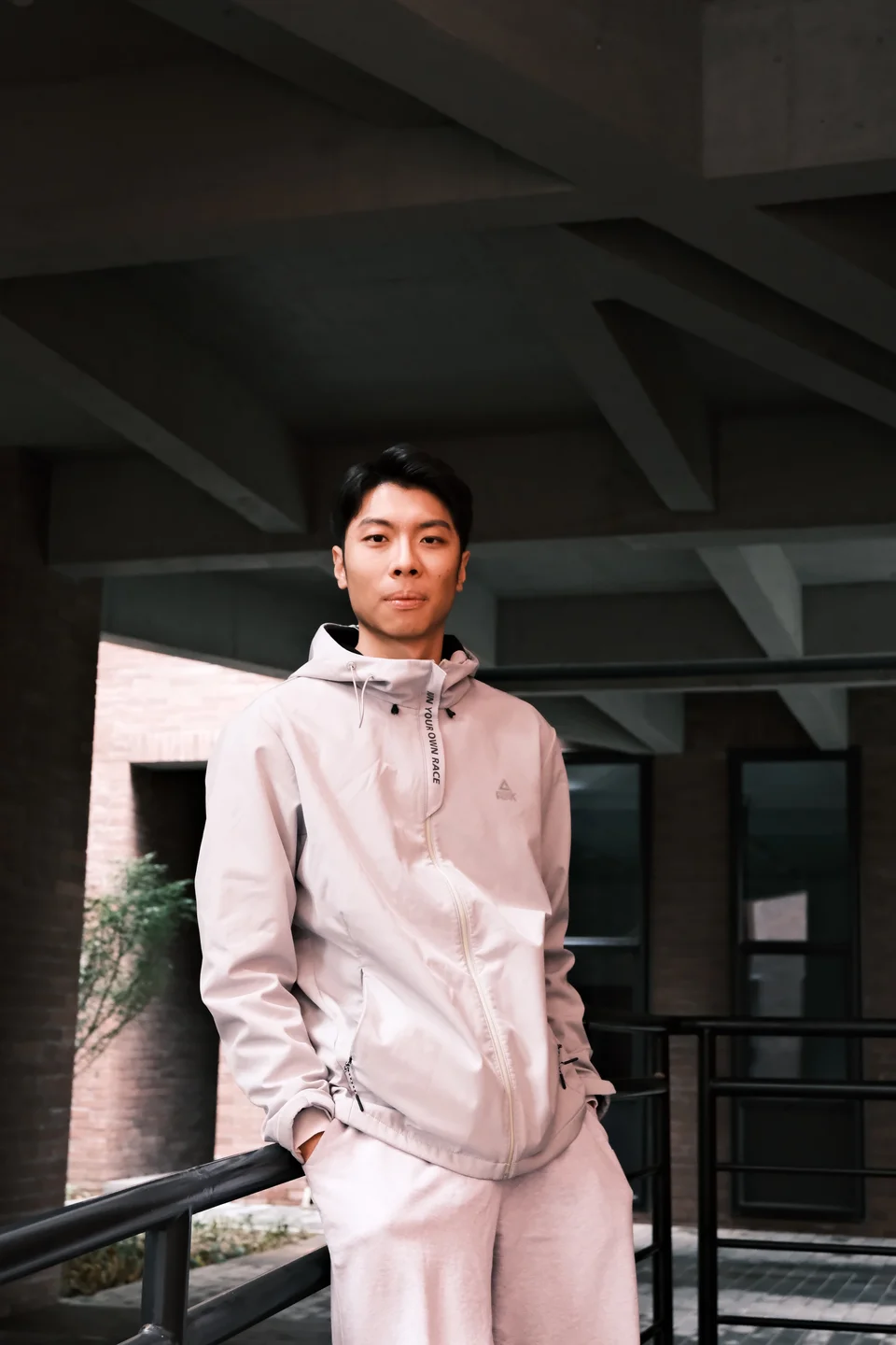 Siyuan Xue outdoors in light athletic wear against concrete architecture
